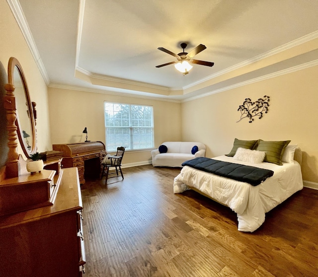 bedroom featuring ceiling fan, ornamental molding, wood-type flooring, and a raised ceiling