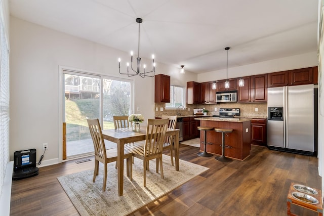 dining room featuring sink, dark wood-type flooring, and a chandelier