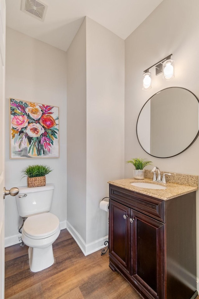 bathroom with vanity, wood-type flooring, and toilet