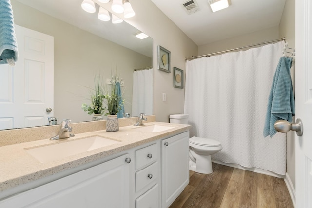 bathroom featuring vanity, wood-type flooring, and toilet