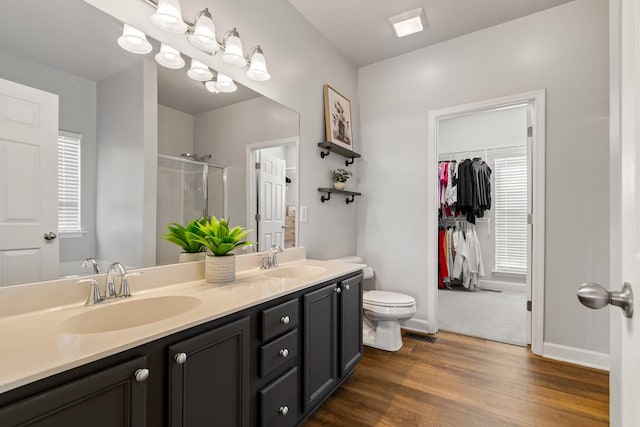 bathroom with hardwood / wood-style flooring, vanity, toilet, and an enclosed shower