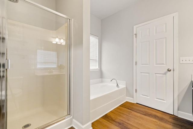 bathroom featuring hardwood / wood-style flooring and separate shower and tub