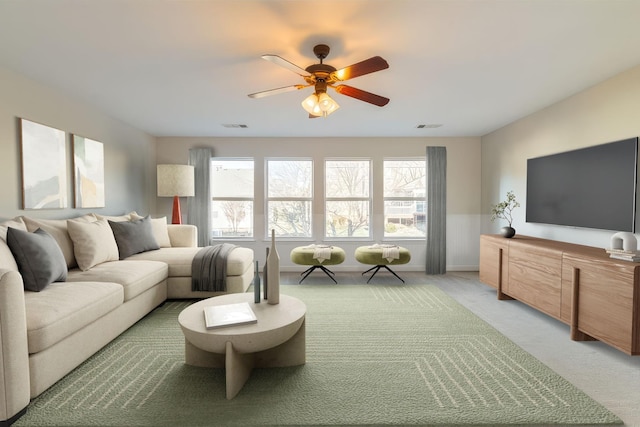 carpeted living room with ceiling fan