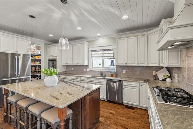 kitchen featuring pendant lighting, sink, a breakfast bar area, stainless steel appliances, and a kitchen island