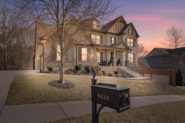 view of front facade with a garage, a yard, and covered porch