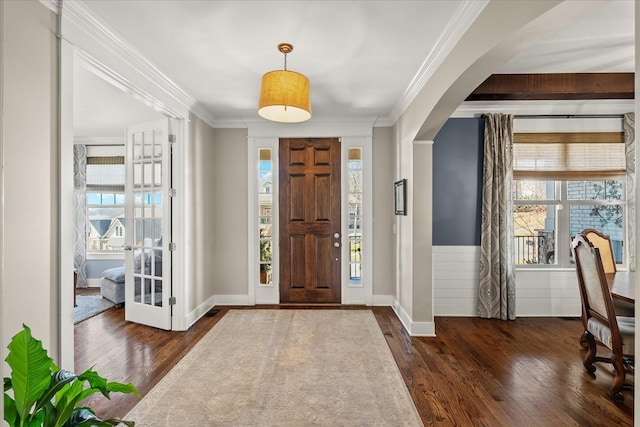 entrance foyer featuring crown molding, dark wood-type flooring, and plenty of natural light