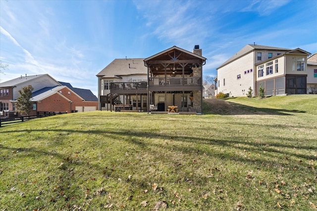 rear view of house featuring a wooden deck and a yard