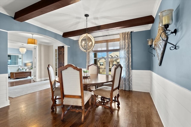 dining room with beamed ceiling, dark hardwood / wood-style floors, a chandelier, and crown molding