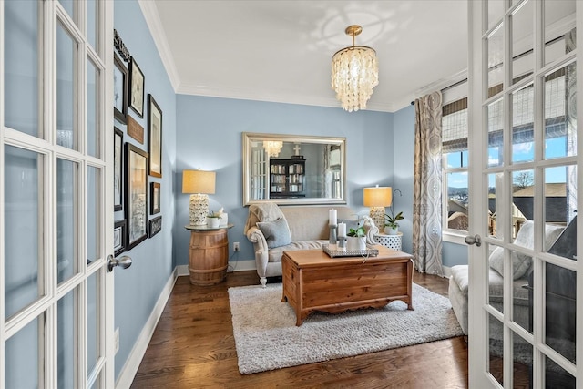 sitting room featuring a notable chandelier, crown molding, dark wood-type flooring, and french doors