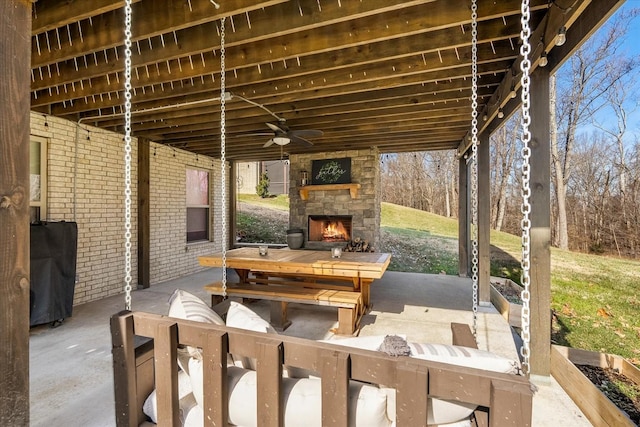 view of patio / terrace with ceiling fan and an outdoor stone fireplace