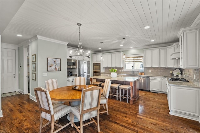 dining area with sink, ornamental molding, a notable chandelier, dark wood-type flooring, and wooden ceiling