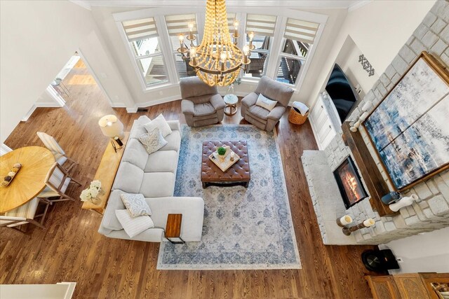 living room with wood-type flooring, crown molding, and a chandelier