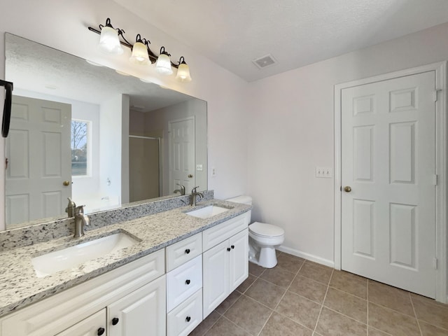 bathroom with walk in shower, tile patterned floors, toilet, a textured ceiling, and vanity