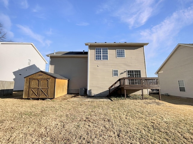 rear view of house featuring cooling unit, a wooden deck, a yard, and a storage unit