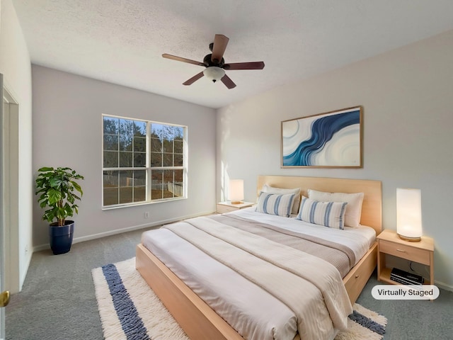 carpeted bedroom featuring ceiling fan and a textured ceiling