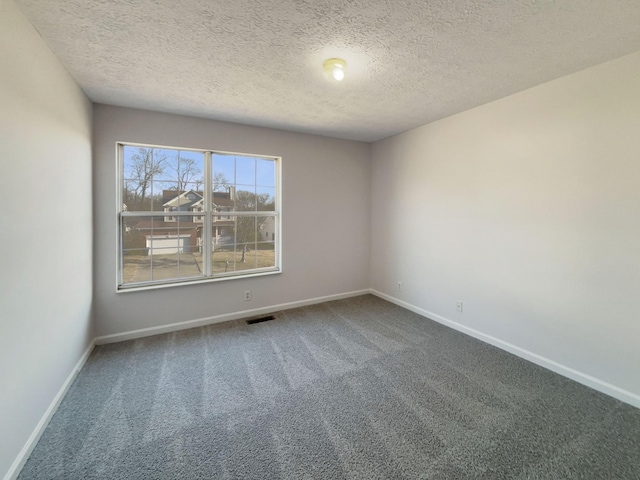 carpeted spare room featuring a textured ceiling