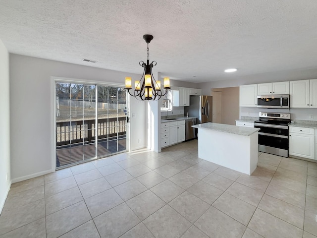 kitchen featuring sink, white cabinetry, hanging light fixtures, stainless steel appliances, and light tile patterned flooring