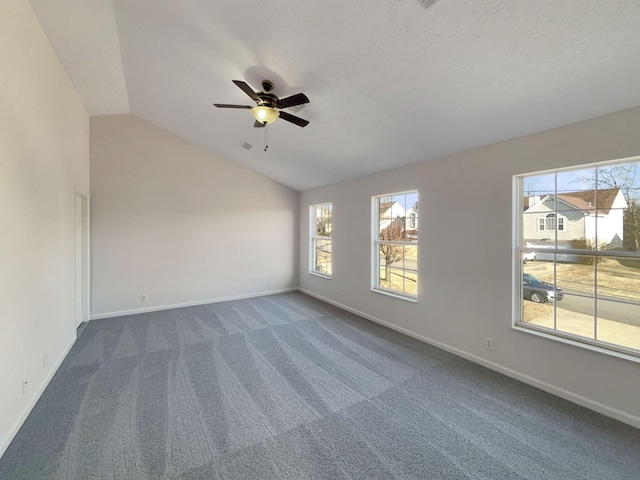 carpeted empty room featuring ceiling fan, plenty of natural light, and vaulted ceiling