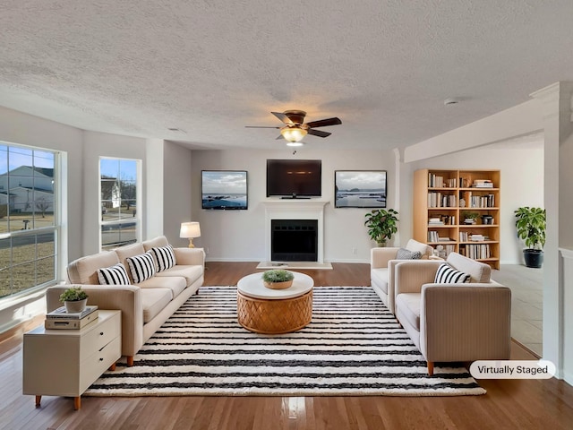 living room featuring hardwood / wood-style floors, a textured ceiling, and ceiling fan