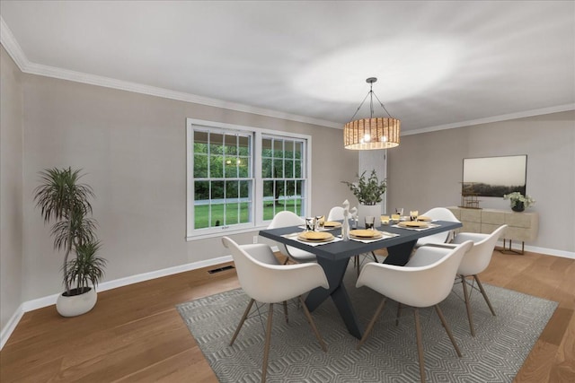 dining area featuring hardwood / wood-style floors and crown molding