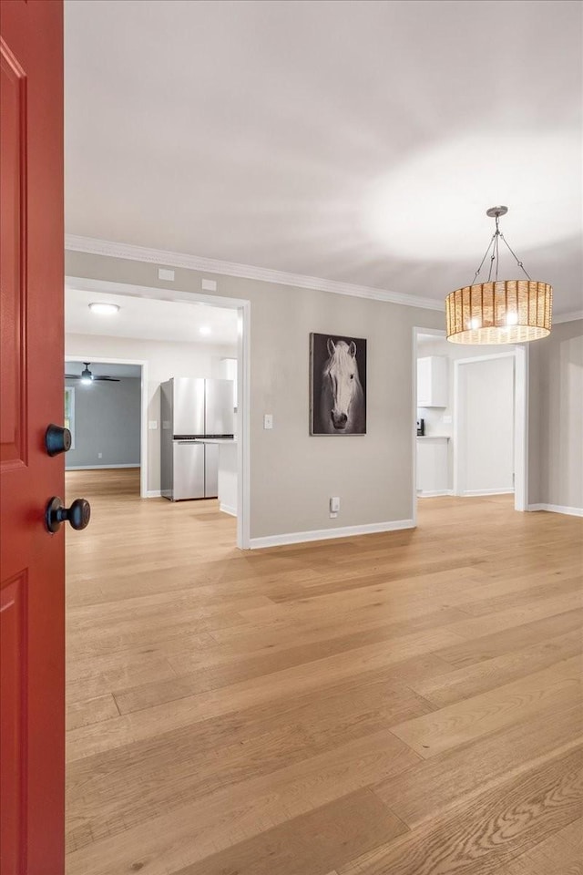 unfurnished living room featuring crown molding, ceiling fan, and light wood-type flooring