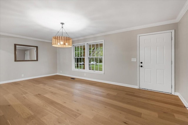 interior space with an inviting chandelier, ornamental molding, and light hardwood / wood-style floors