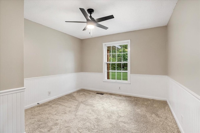 empty room with light colored carpet and ceiling fan