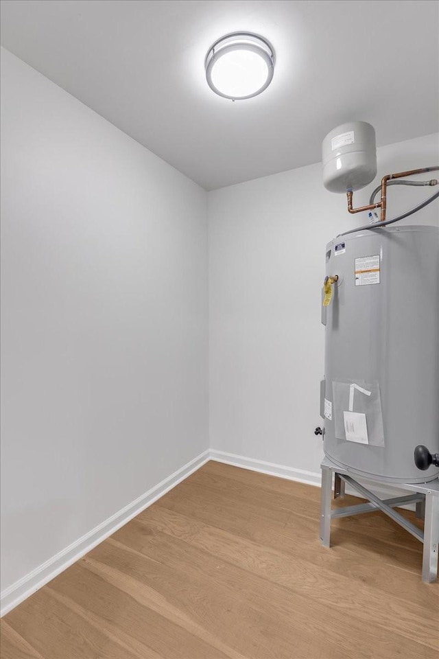 interior space with wood-type flooring and electric water heater