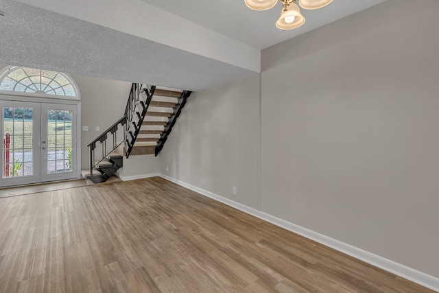 entrance foyer with hardwood / wood-style flooring, french doors, and a textured ceiling