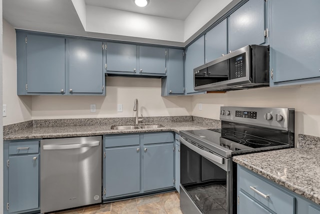 kitchen featuring sink, stainless steel appliances, and blue cabinetry