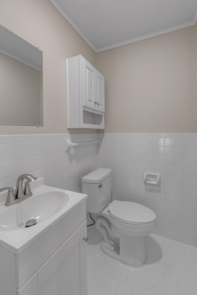 bathroom featuring vanity, ornamental molding, tile walls, and toilet