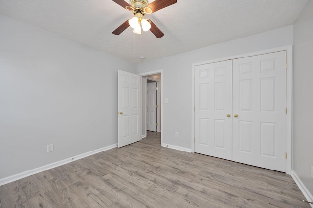 unfurnished bedroom with a closet, a textured ceiling, ceiling fan, and light hardwood / wood-style floors