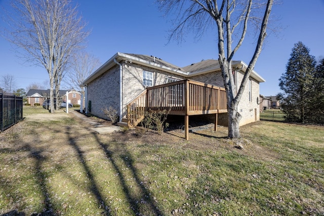 rear view of property with a deck and a lawn