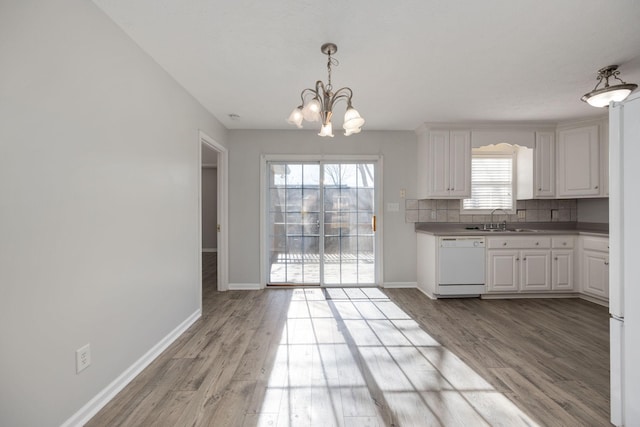 kitchen featuring white cabinets, dishwasher, a healthy amount of sunlight, and backsplash