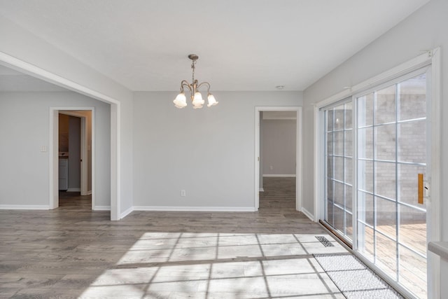 unfurnished room featuring an inviting chandelier and light wood-type flooring