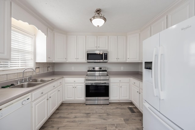 kitchen featuring white cabinetry, appliances with stainless steel finishes, sink, and light hardwood / wood-style flooring