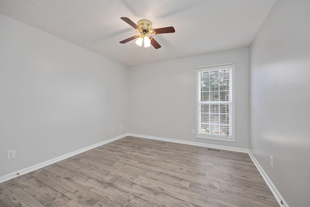 spare room featuring ceiling fan, light hardwood / wood-style floors, and a textured ceiling