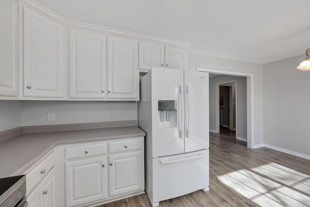 kitchen featuring light hardwood / wood-style flooring, white refrigerator with ice dispenser, white cabinets, and range