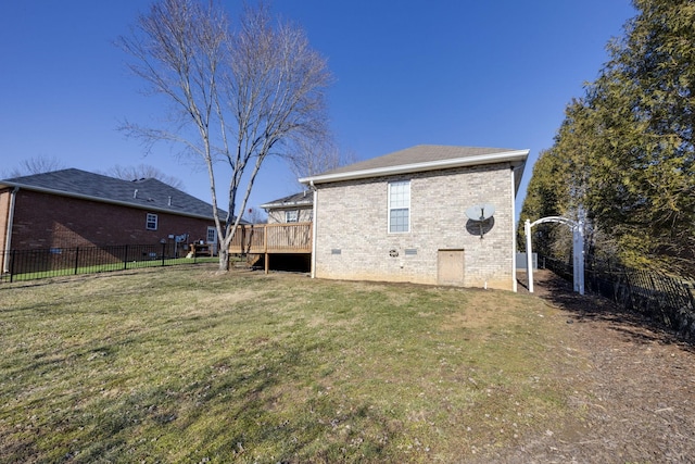 back of property featuring a deck and a lawn