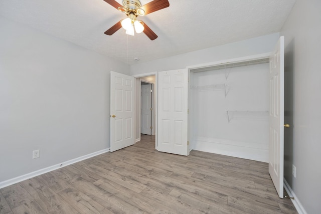 unfurnished bedroom with a textured ceiling, a closet, ceiling fan, and light wood-type flooring