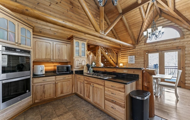 kitchen featuring high vaulted ceiling, log walls, a chandelier, wood ceiling, and stainless steel appliances