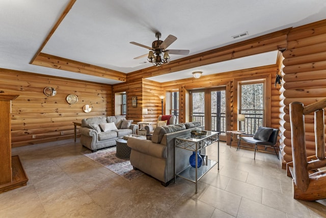 living room with ceiling fan, rustic walls, and a raised ceiling