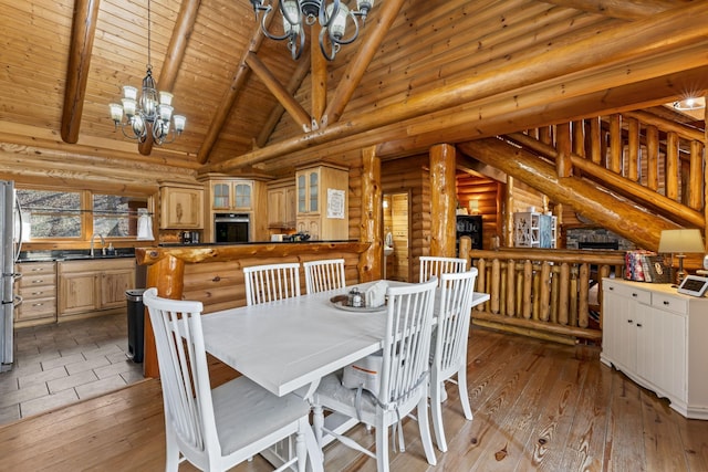 dining area with beamed ceiling, high vaulted ceiling, log walls, and light hardwood / wood-style floors