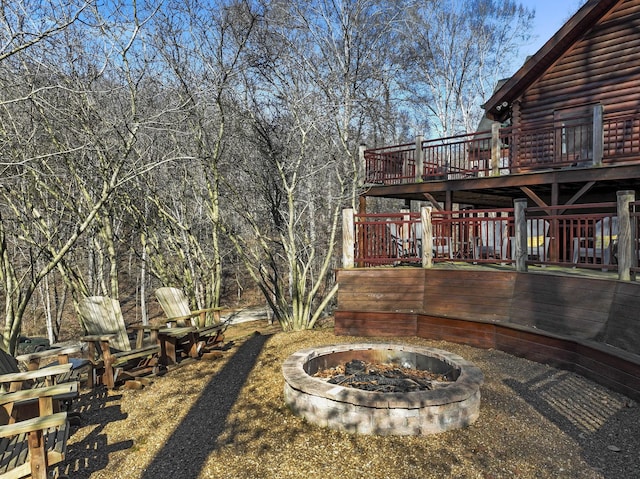 view of yard featuring a deck and a fire pit