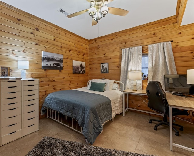 bedroom featuring light tile patterned floors, ceiling fan, and wood walls