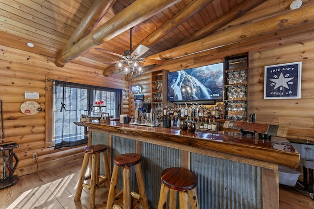 bar with vaulted ceiling with beams, log walls, light hardwood / wood-style floors, and wooden ceiling