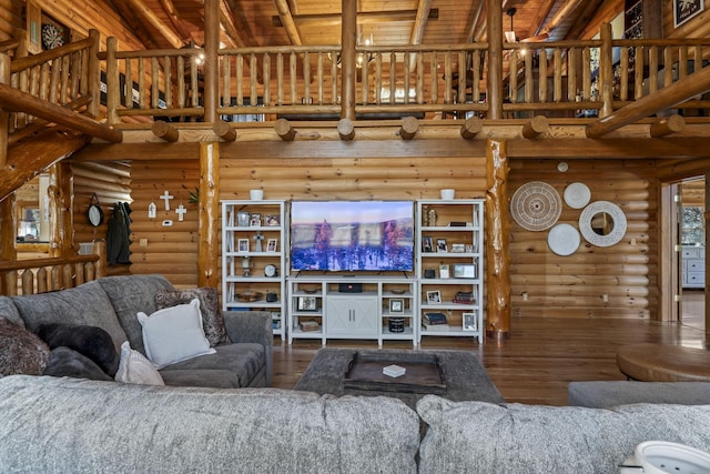 living room featuring log walls, wood-type flooring, and a high ceiling