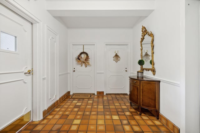 foyer entrance featuring beam ceiling