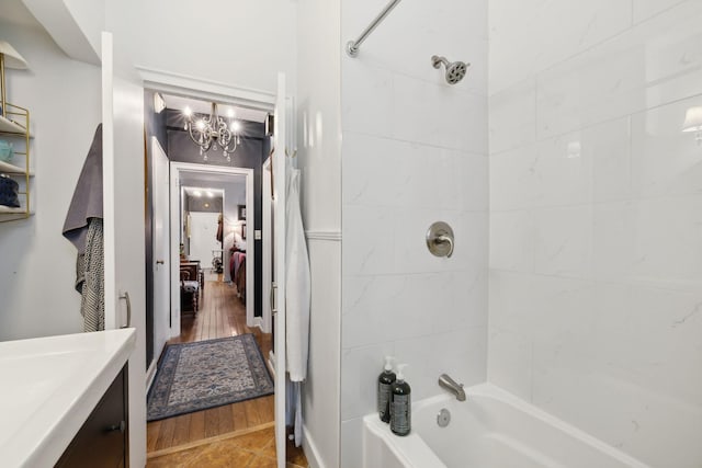 bathroom with vanity, a notable chandelier, and tiled shower / bath combo