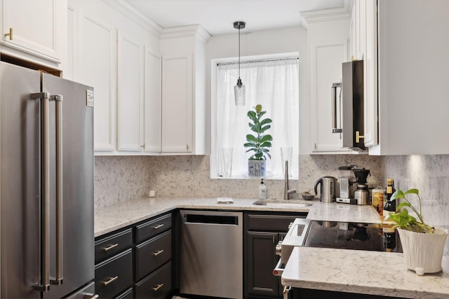 kitchen with pendant lighting, appliances with stainless steel finishes, a wealth of natural light, and white cabinets